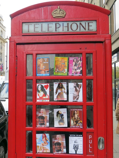 Prostitute calling cards in red phone in Piccadilly, Central London 