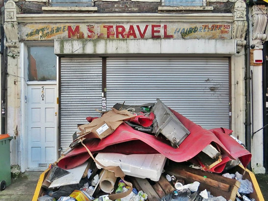 Closed down shop in Manor Park, East London. The fading sign reveals clues of travel, mortgages and hairdressers.